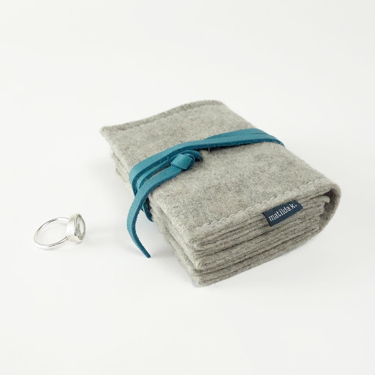 schmuckaufbewahrung-m-minimalistisch-aus-wollfilz-hellgrau-lederband-tuerkis-matilda-k-